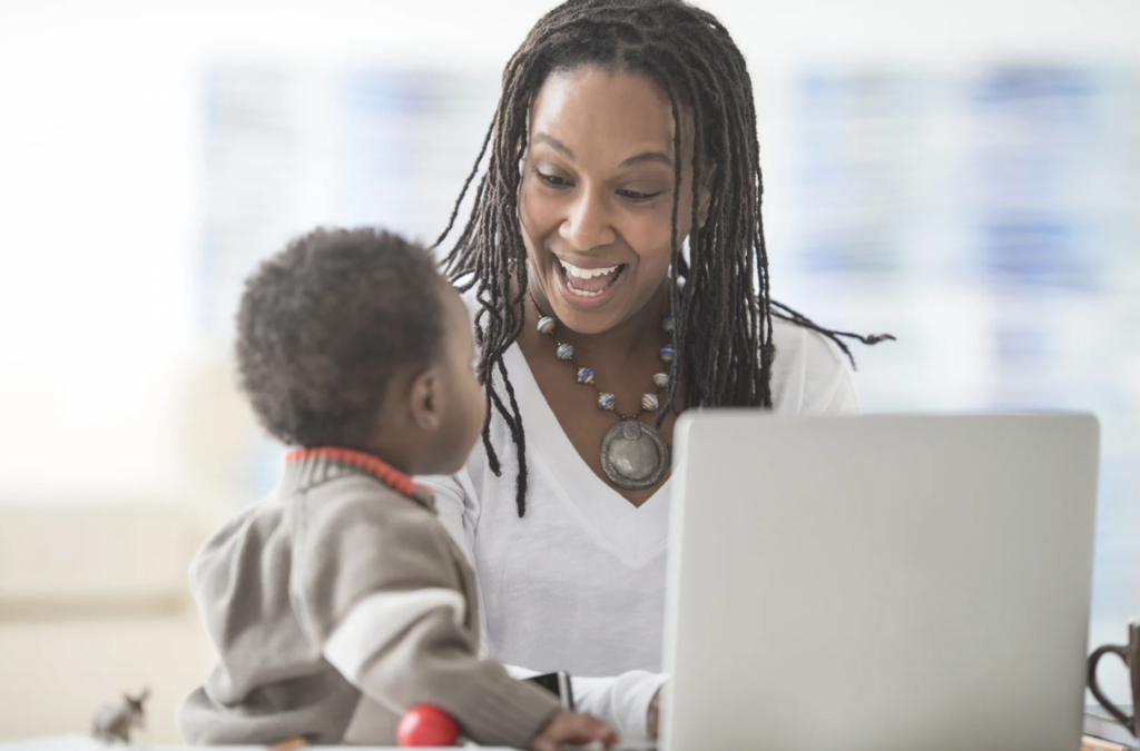 Women working at computer smiling at baby